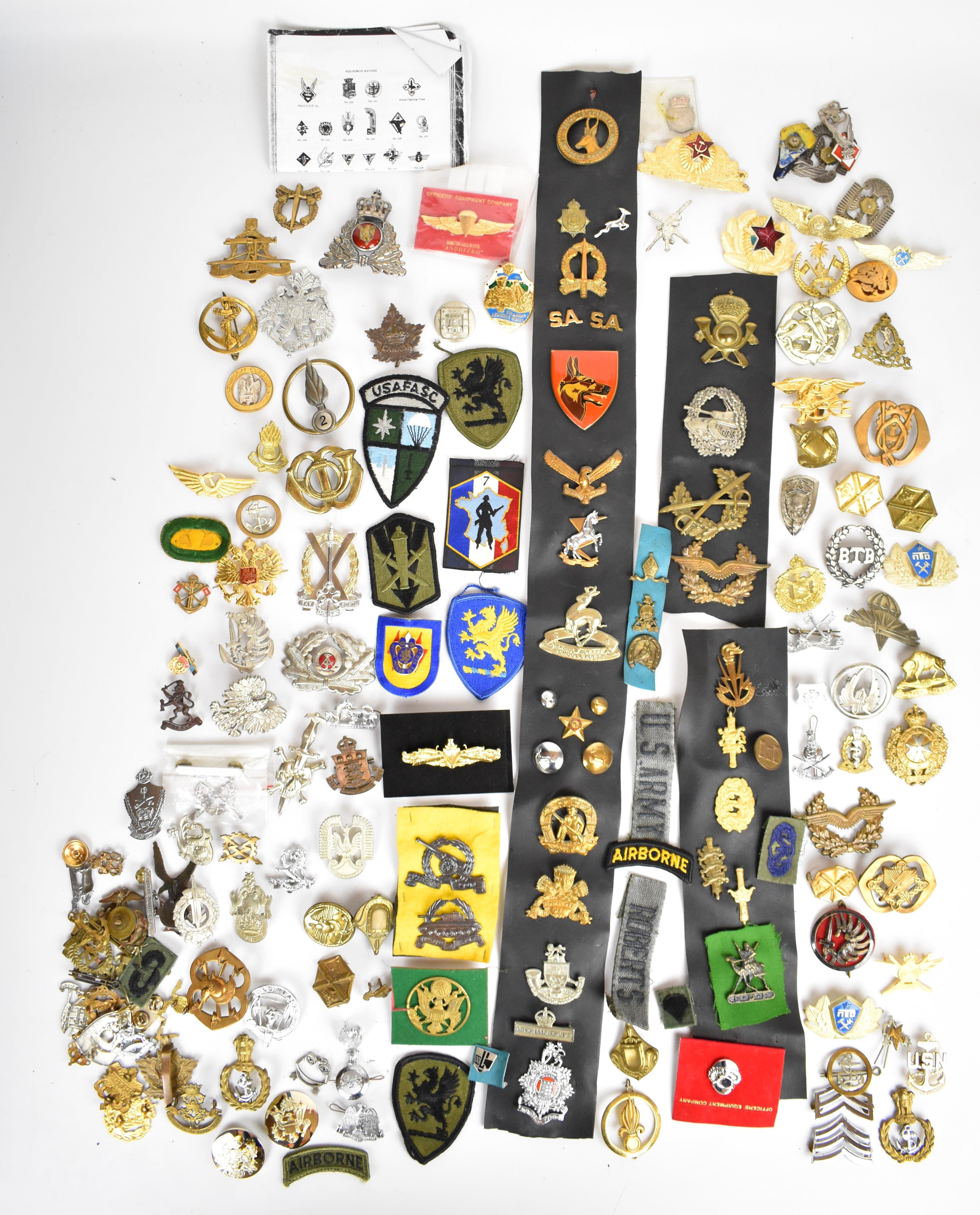 Large collection of approximately 100 overseas forces badges including South Africa, France, Canada,