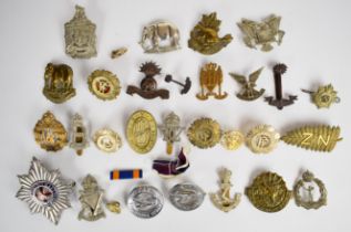 Collection of approximately 25 military cap badges including British Asia slouch hat badge, 22nd