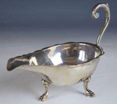 Hallmarked silver sauce boat with scroll handle, raised on three feet, marks rubbed, length 18.