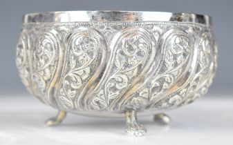 Indian, Burmese or similar silver bowl with lobed embossed decoration, raised on three feet,