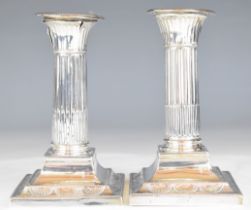Pair of Victorian hallmarked silver candlesticks with reeded columns and square bases, London