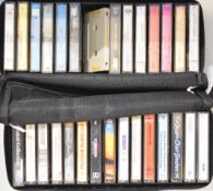 Approximately sixty five mixed genre cassettes in three vintage cases including Queen, Santana, Pink