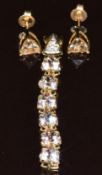 A 9k gold pendant set with six trilliant cut morganites and three diamonds (1.7g, 4.4cm long) and