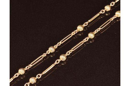 A c1920 9ct gold guard chain made up of ridged spherical beads and elongated links, 14g, 84cm - Image 1 of 8