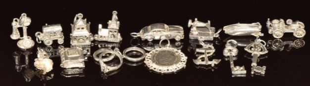 Fourteen silver charms including temple opening to reveal a monk, sewing machine, car, church, car