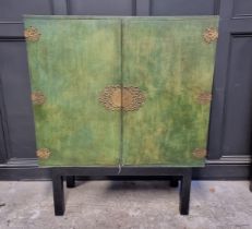 A decorative green stained and polychrome painted cabinet, the interior with an arrangement of