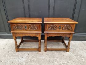 A pair of 'Old Charm' oak bedside tables, 56.5cm wide. (2)