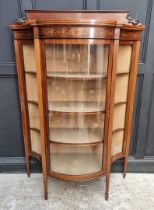 A circa 1900 mahogany and inlaid serpentine fronted display cabinet, 119.5cm wide.