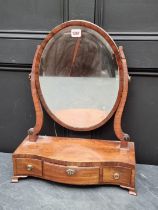 A George III mahogany and chequer strung serpentine toilet mirror, 43cm wide.