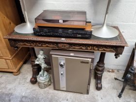 A Victorian carved oak shallow library type table, of freestanding form, with leather inset surface,