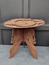 An Oriental carved hardwood tripod table, with dragon decoration, 64cm diameter.