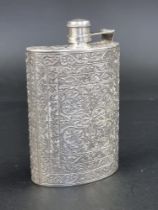 An Indian white metal hip flask, having chased floral decoration, 14cm high, 181g.