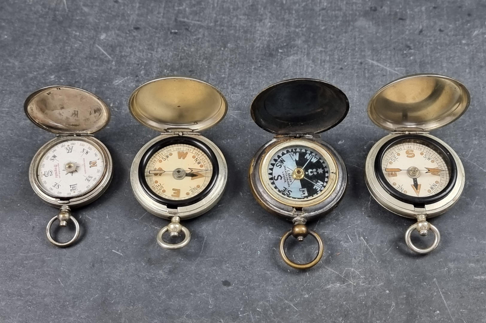 Two WWI military style nickel plated compasses; together with two other pocket compasses. (4)