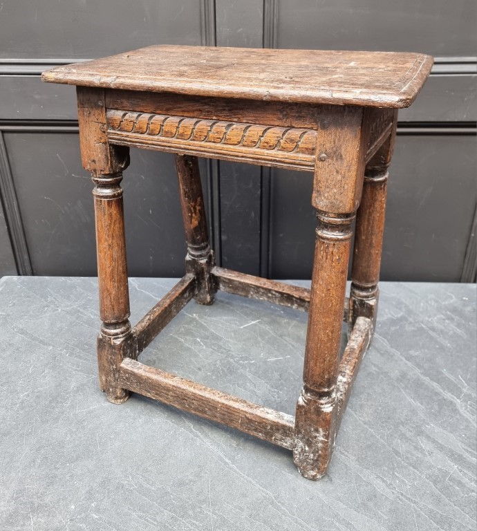 A 17th century carved oak joint stool, 49cm wide.