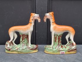 A pair of Victorian Staffordshire pottery greyhound and rabbit figure groups, 28cm high.