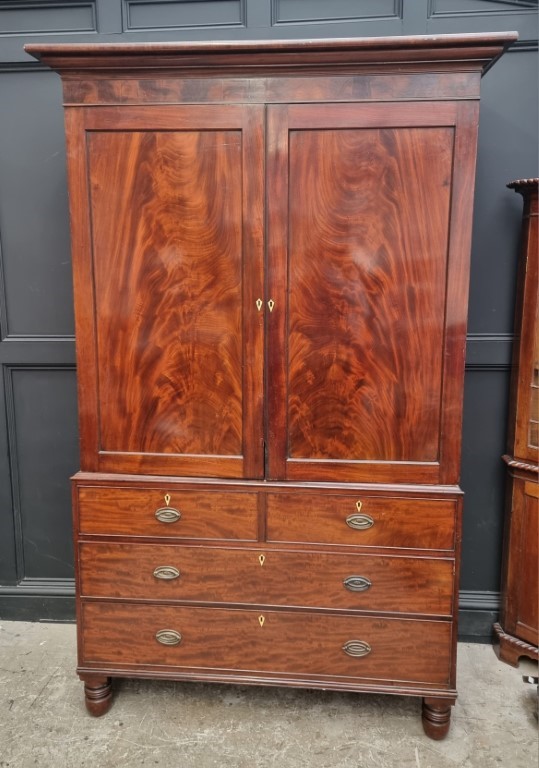 A large George IV mahogany linen press, possibly Scottish, with five sliding trays and bone