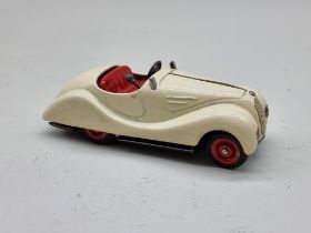 Schuco: a vintage (1950s) cream Examico 4001 clockwork car, (no key, base partially detached).