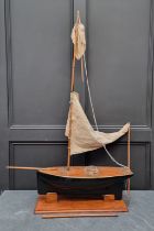 A vintage pond yacht, the hull 66cm long, on mahogany stand.