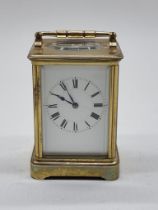 An old brass carriage timepiece, height including handle 18cm.