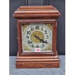 An old stained oak mantel clock, 33cm high, with pendulum.