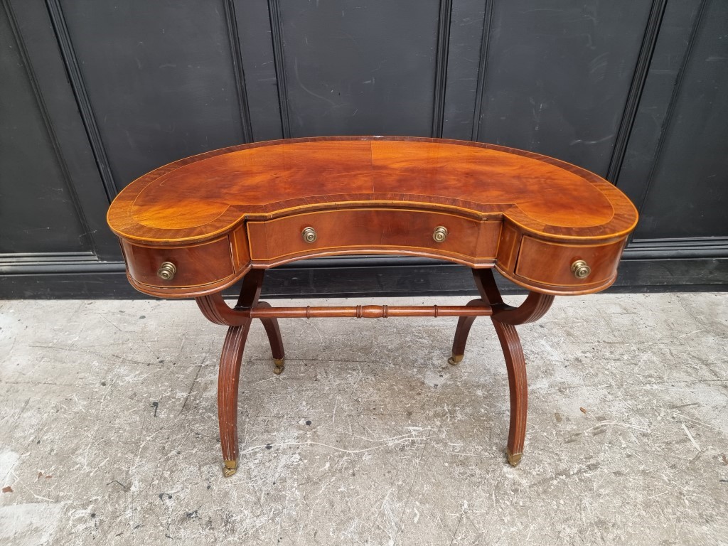 A reproduction mahogany and line inlaid kidney shaped desk, 99cm wide.