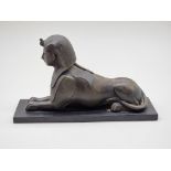 A bronze sphynx, on slate base, 28cm long.