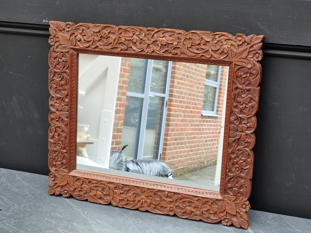 A Thai carved hardwood framed wall mirror, 42 x 50cm.