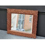 A Thai carved hardwood framed wall mirror, 42 x 50cm.