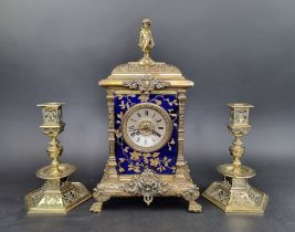 An impressive Victorian brass and porcelain clock garniture, the panels by Taylor, Tunnicliff &