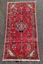 An Iranian rug, with tribal and geometric decoration to central field, 280 x 141cm.