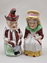 A pair of Victorian Staffordshire pottery 'Punch' and 'Judy' toby jugs and covers, 28.5cm high.
