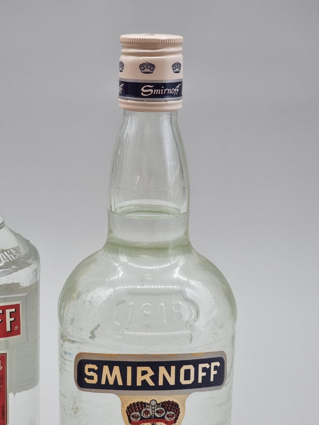 A 1 litre bottle of Smirnoff Vodka, 50% abv, probably 1980s bottling; together with another later - Bild 2 aus 3