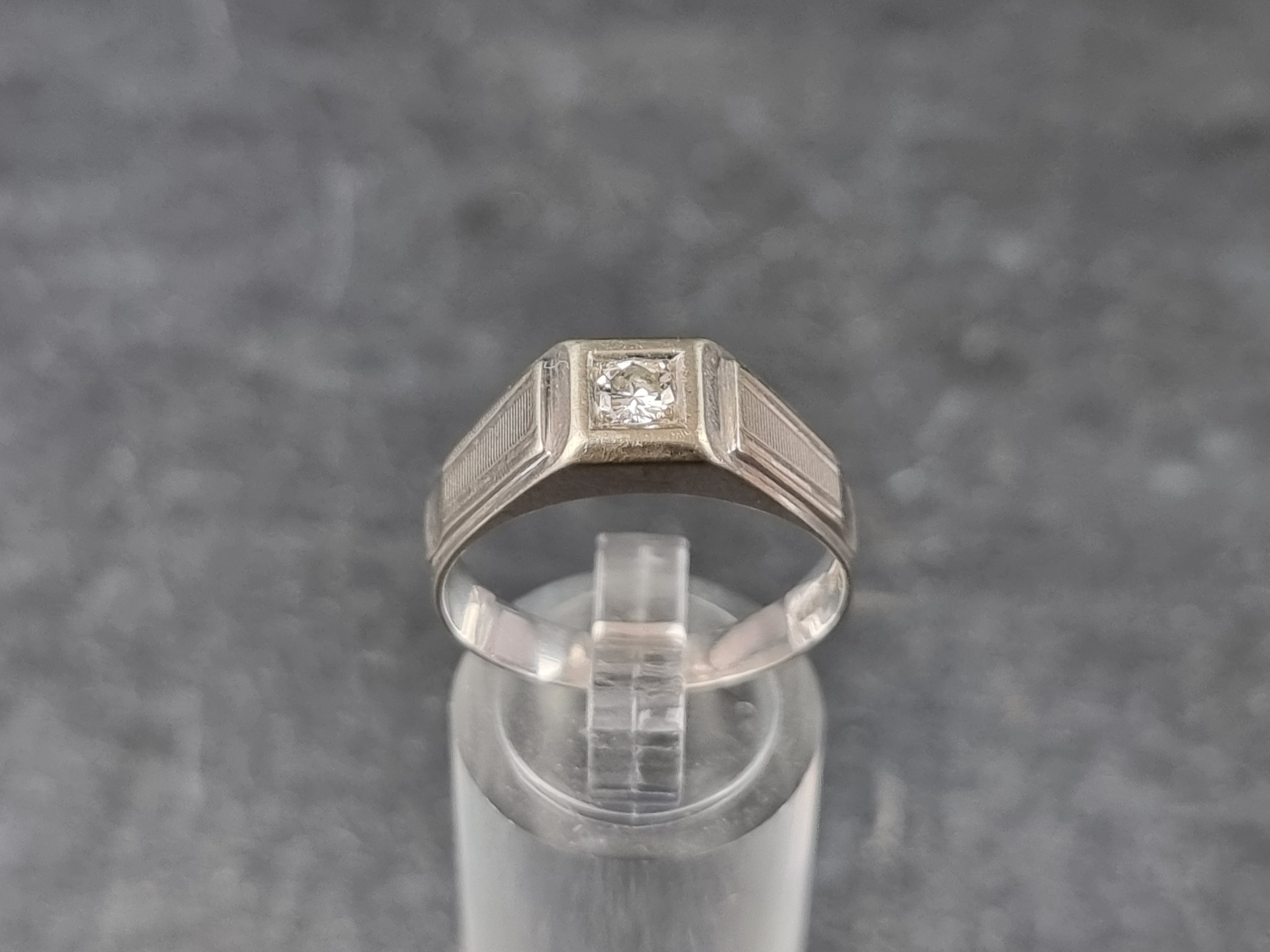 A diamond solitaire ring, stamped '750', size U.