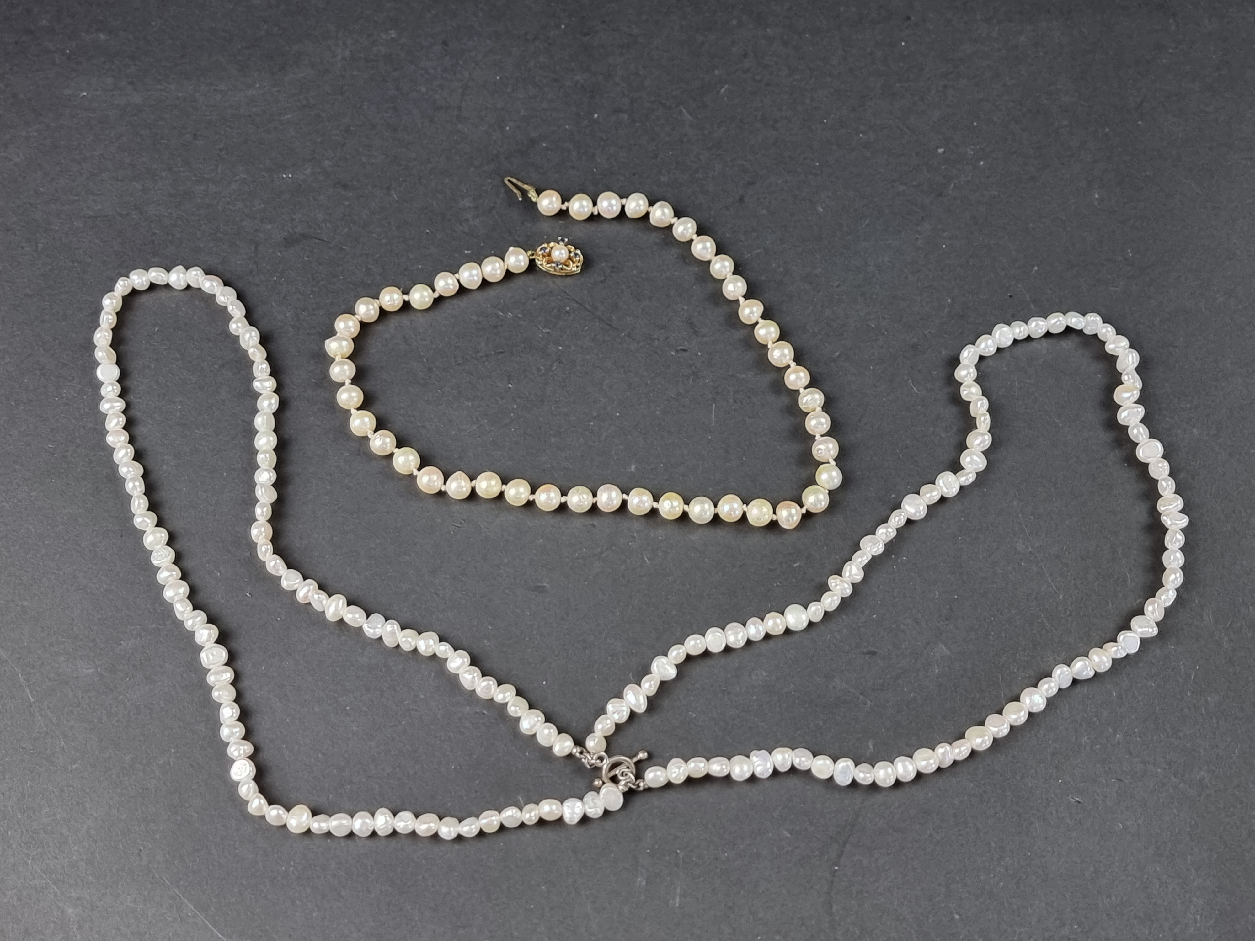 A cultured pearl necklace, having yellow metal clasp set pearl and four sapphires, stamped '9ct',