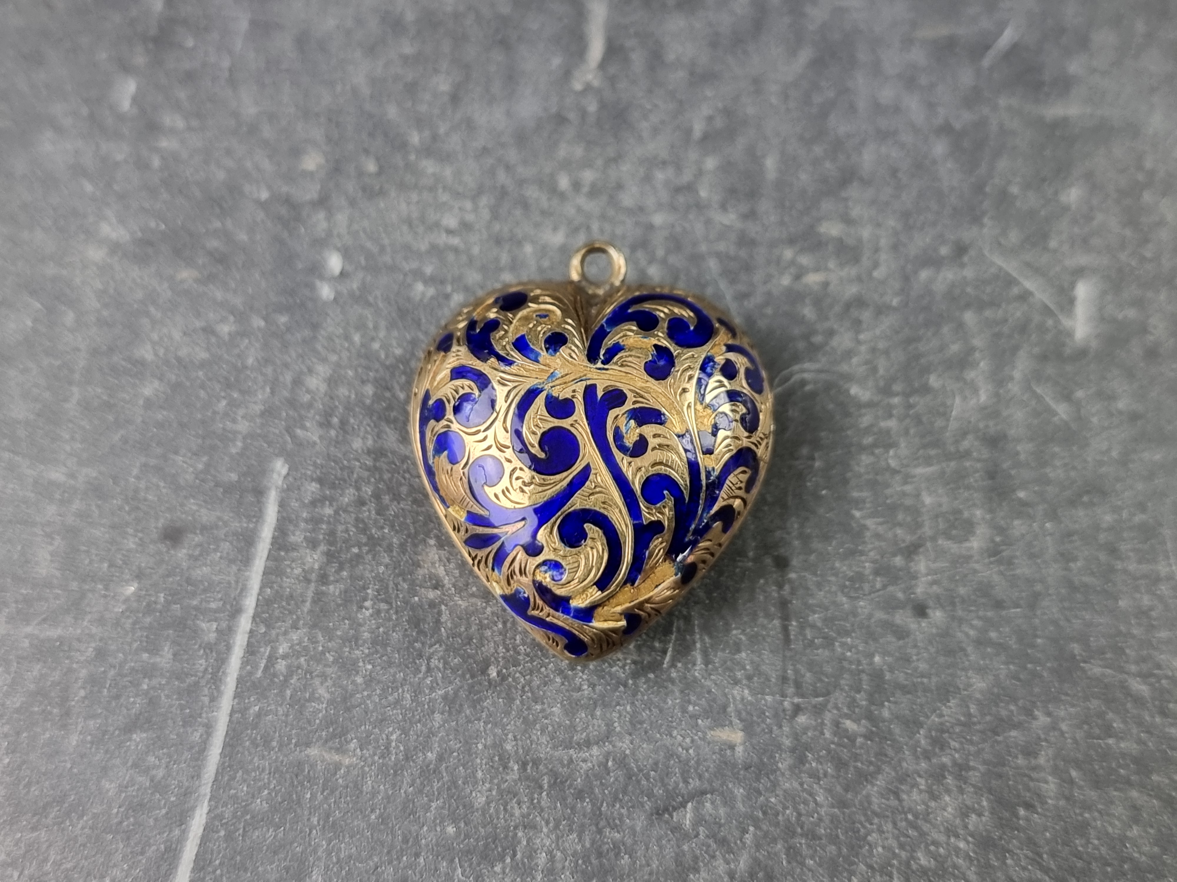 A Victorian heart shaped pendant, decorated in blue enamel, inset lock of hair, engraved 'Somerset