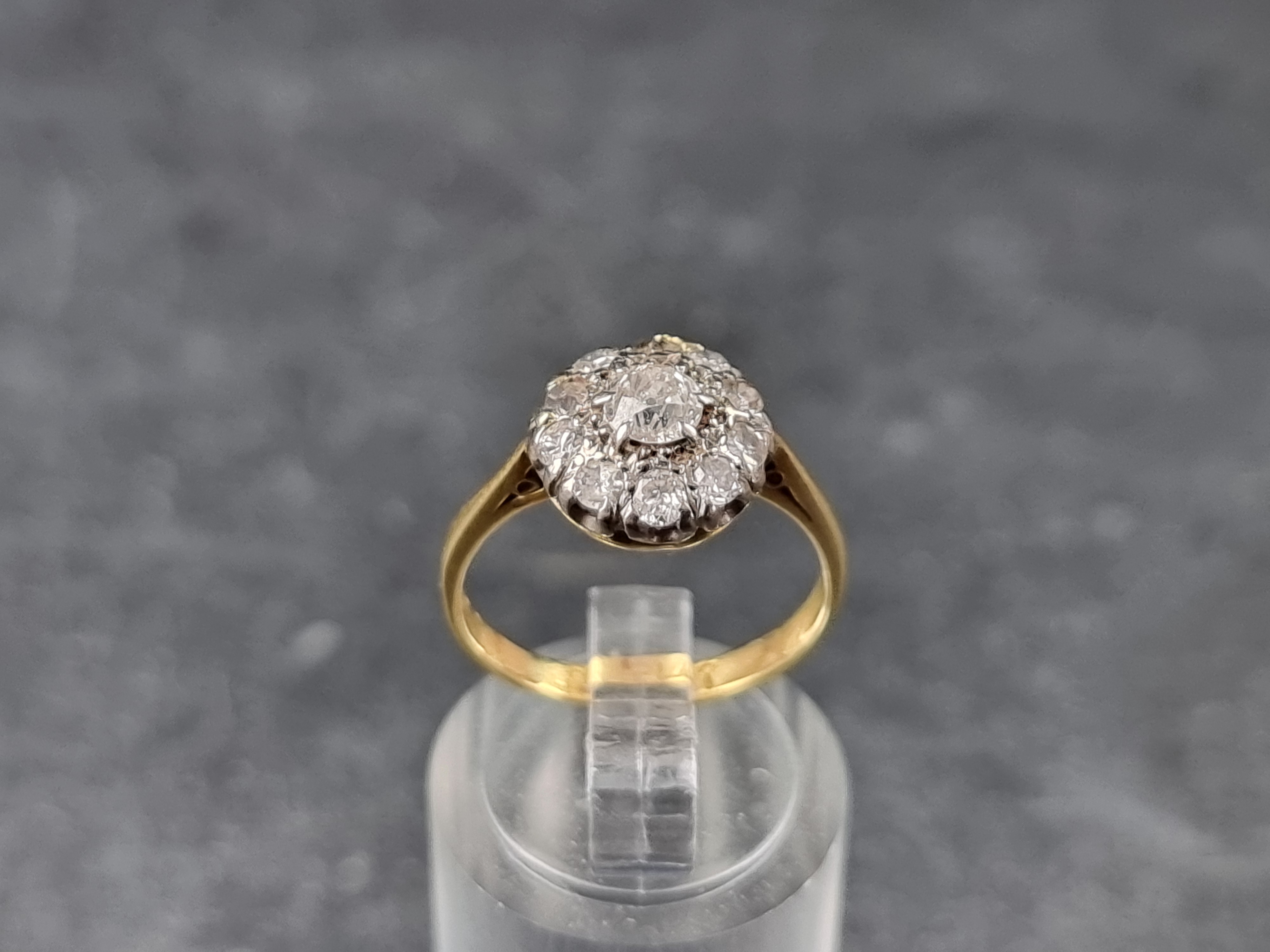 A diamond daisy cluster ring, stamped '18/Plat', size L 1/2.