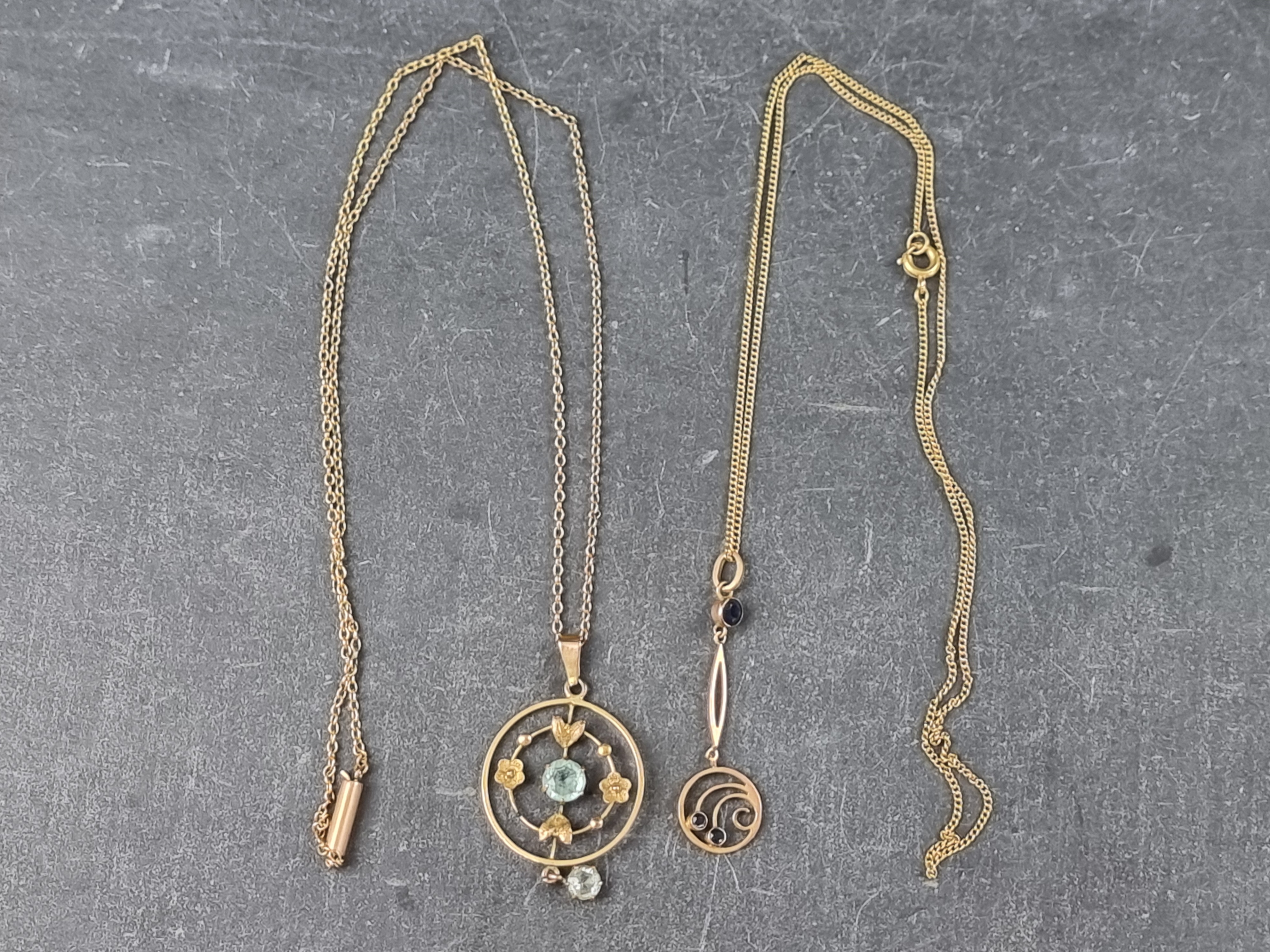 Two gem set yellow metal pendants, on fine chains, all stamped '9ct'.