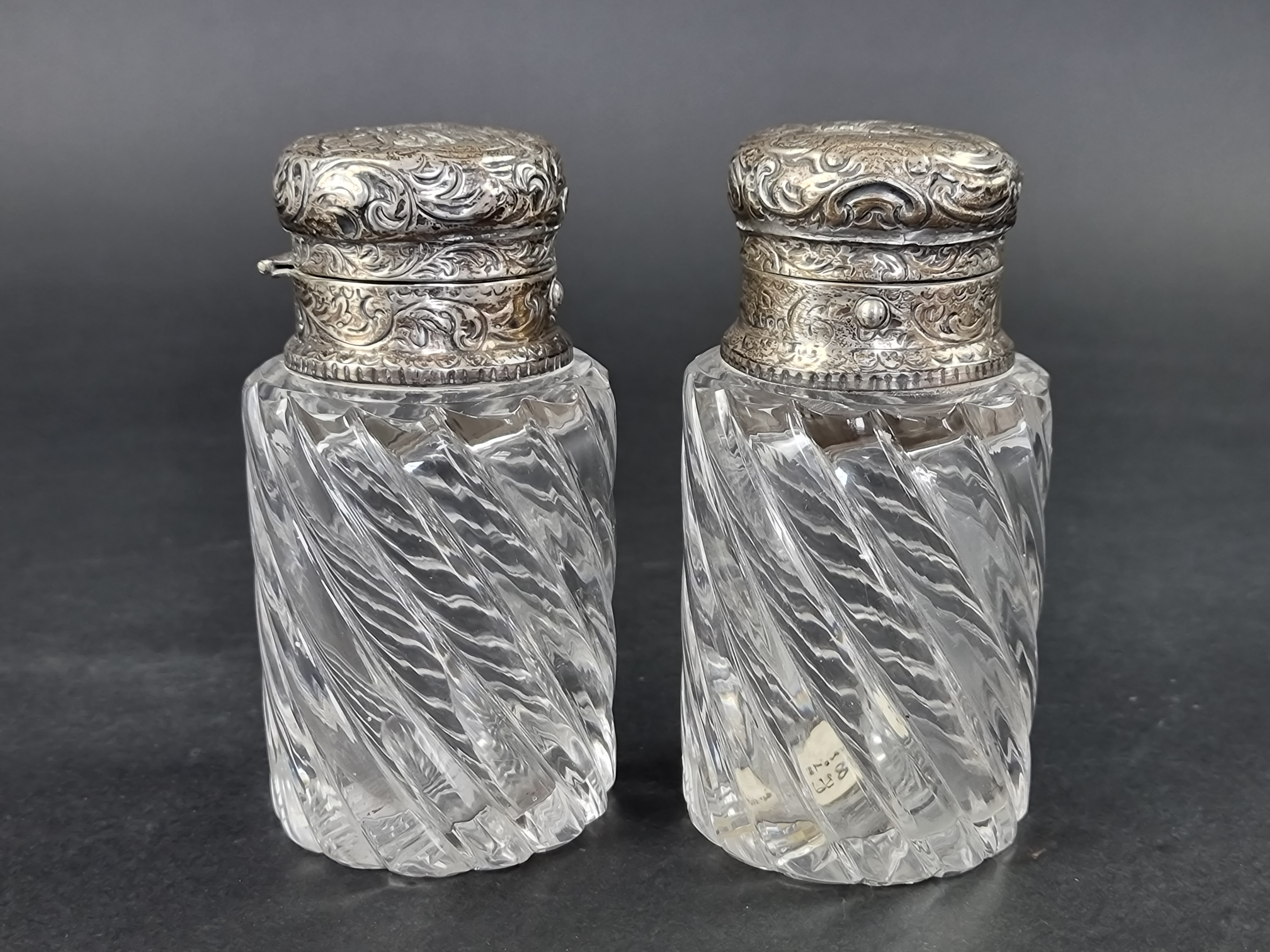 Two Victorian silver mounted scent flasks, maker's mark rubbed, London 1880, 12.5cm high. (2)