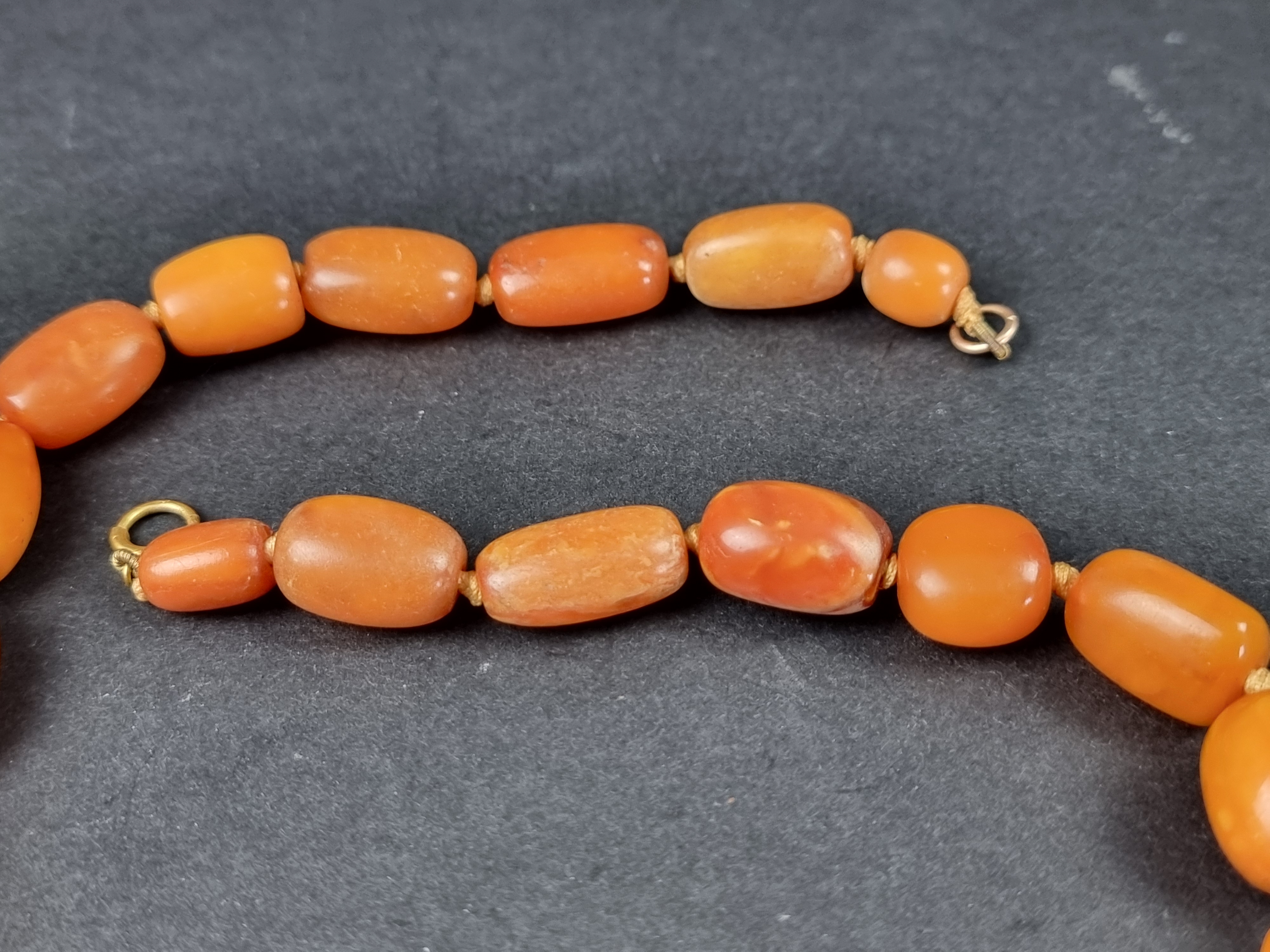 An amber bead necklace, having clasp stamped '375', 46cm long, gross weight 49.1g. - Image 3 of 6