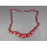 A Bakelite 'cherry amber' necklace, the beads 12-29mm long, gross weight 60g.