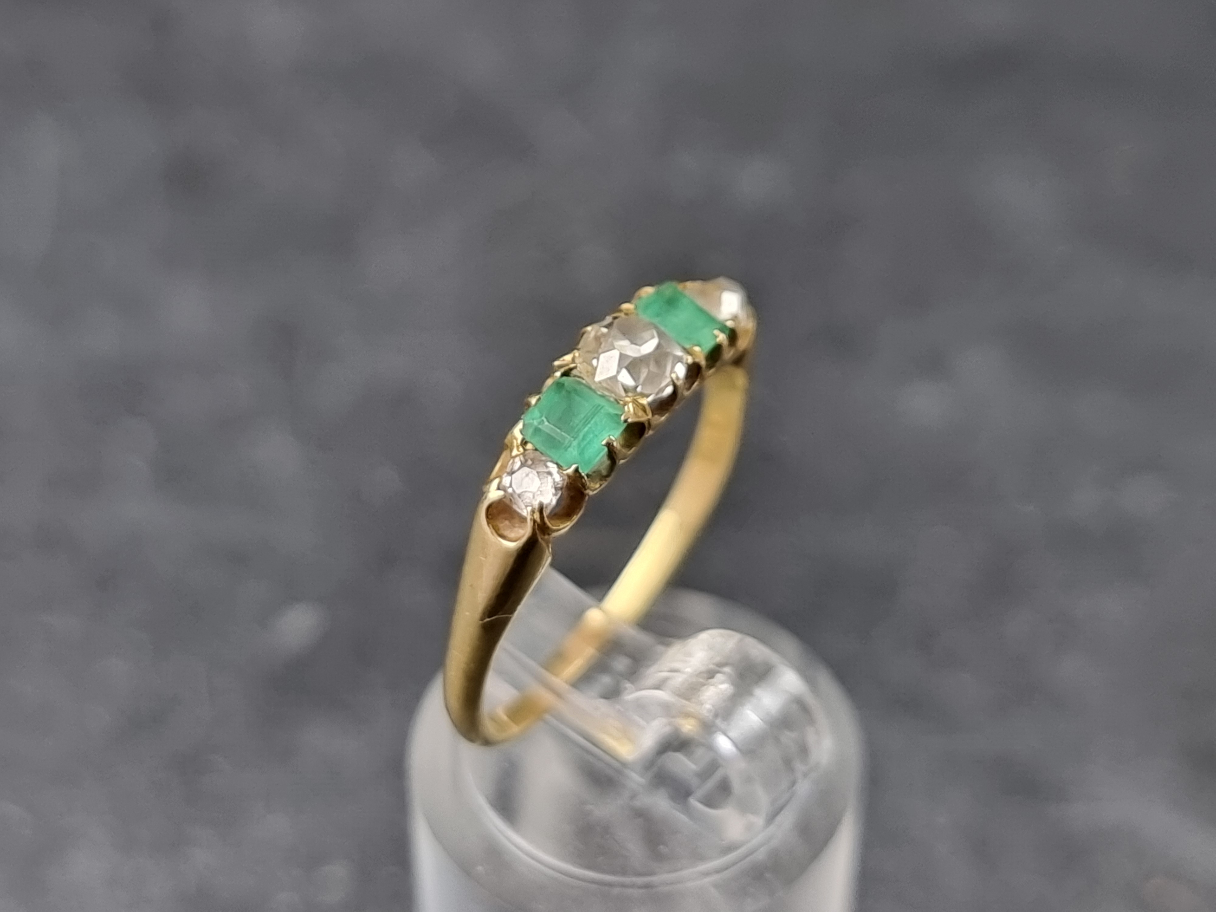 A yellow metal emerald and diamond five stone ring, set three graduated old cut diamonds and two - Image 3 of 3