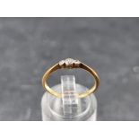 A yellow metal diamond three stone ring, stamped '18ct', size L 1/2.
