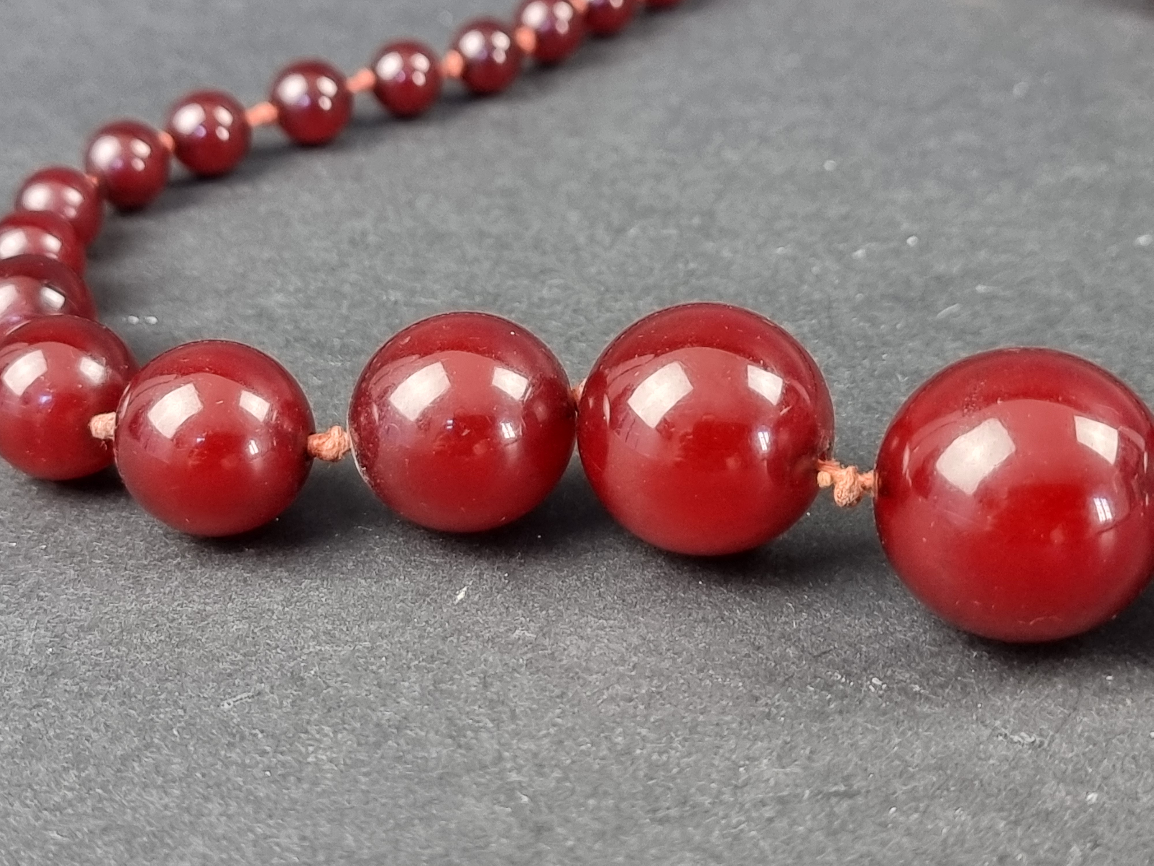 A Bakelite 'cherry amber' bead necklace, the beads 7-21mm diameter, gross weight 46g, 51cm long, - Image 3 of 3