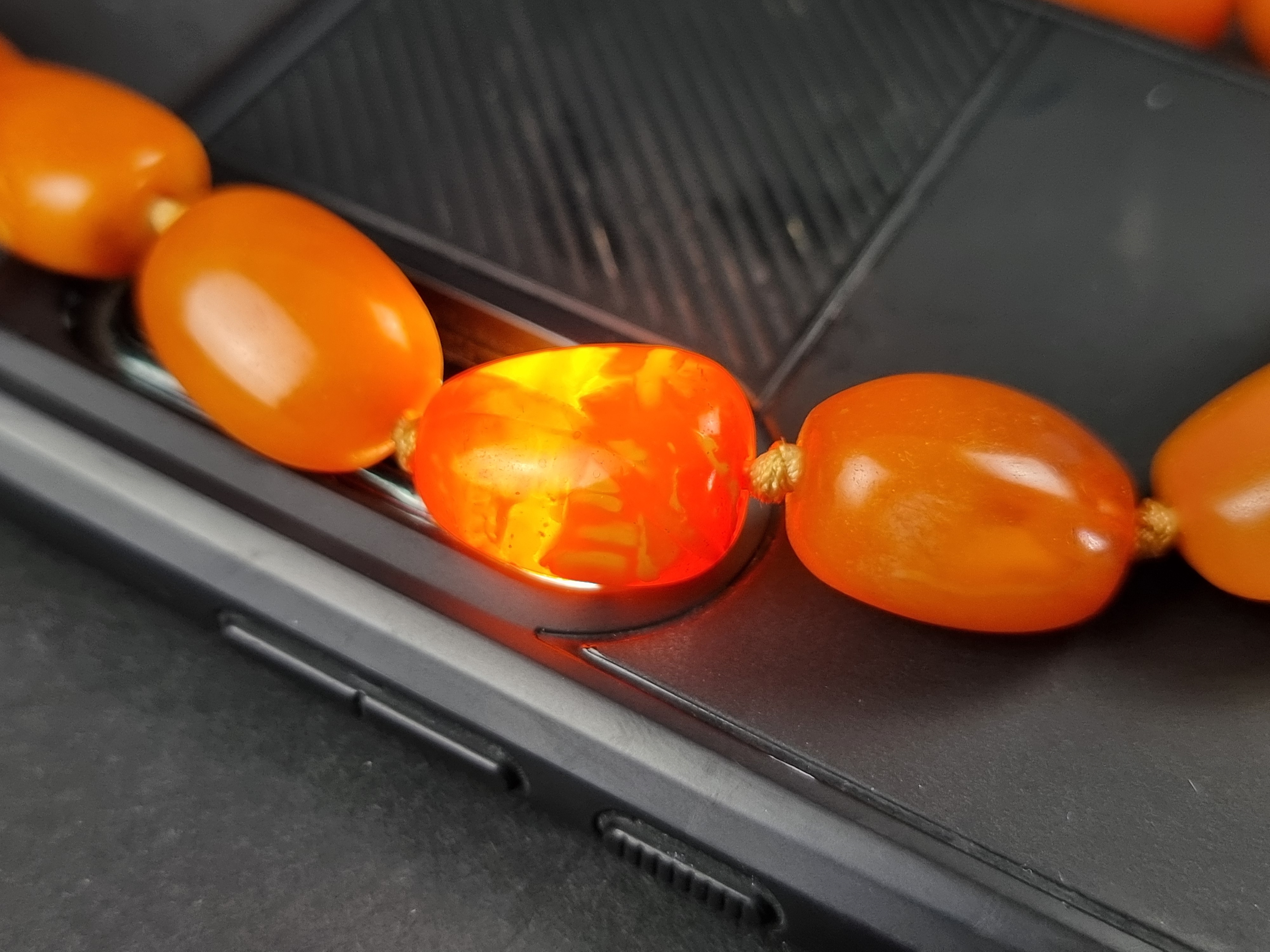 An amber bead necklace, having clasp stamped '375', 46cm long, gross weight 49.1g. - Image 6 of 6