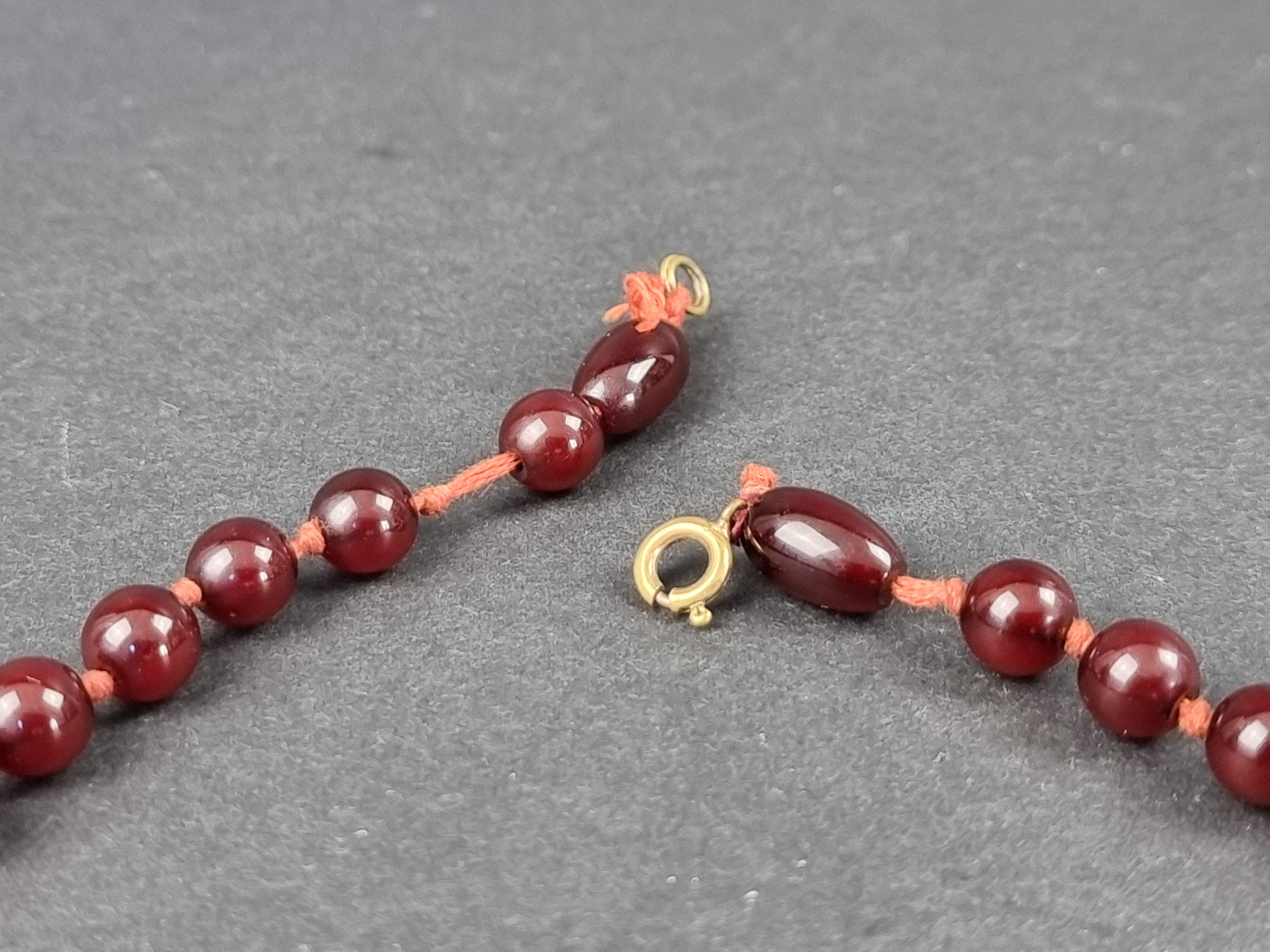 A Bakelite 'cherry amber' bead necklace, the beads 7-21mm diameter, gross weight 46g, 51cm long, - Image 2 of 3