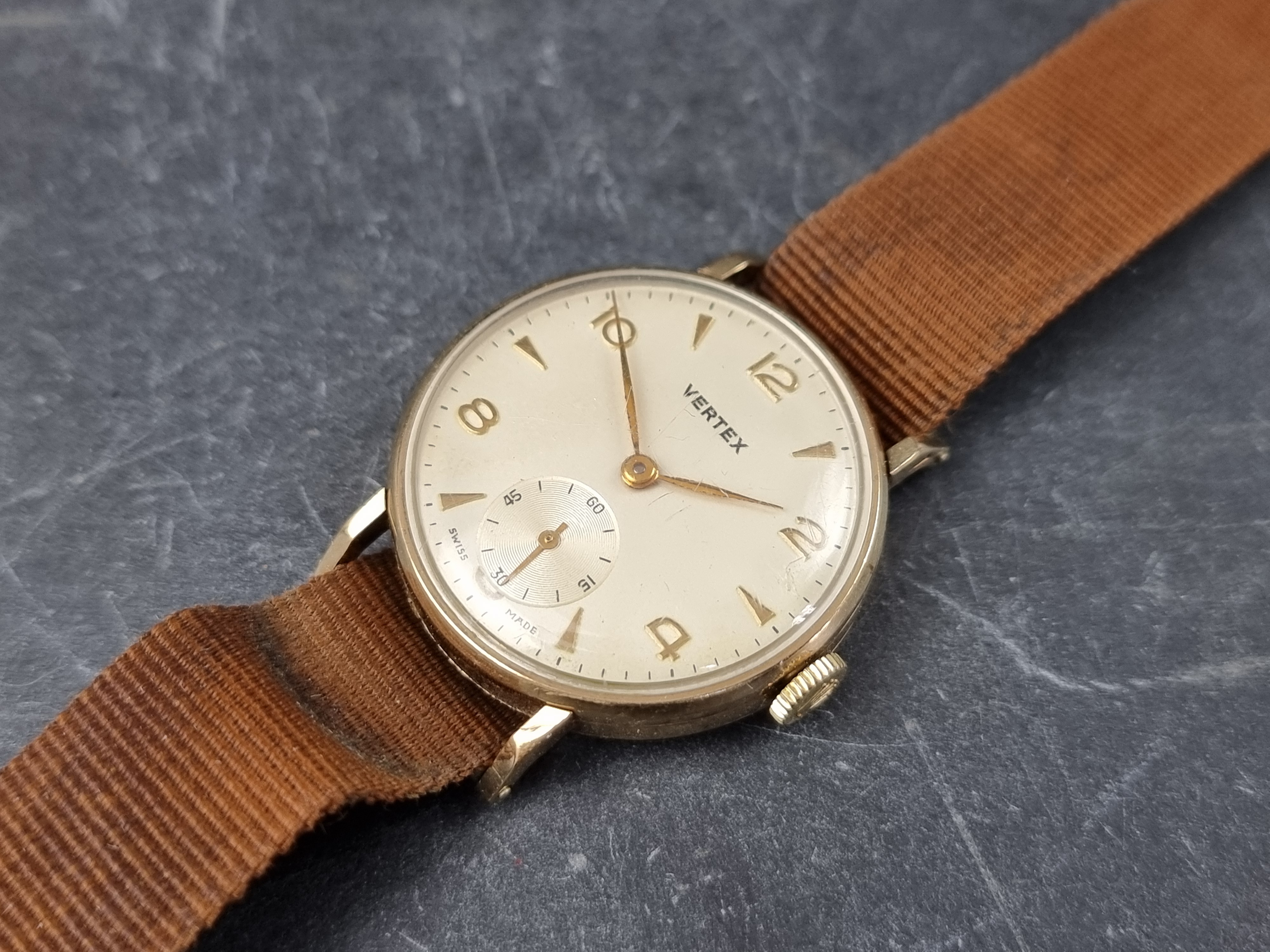 A 1950s Vertex 9ct gold manual wind wristwatch, 31mm, Ref. 712523, on vintage Nato strap.