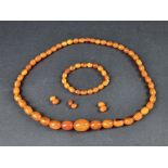 An amber necklace, the beads 9-24mm long, gross weight 39g, 56cm long; together with a similar amber