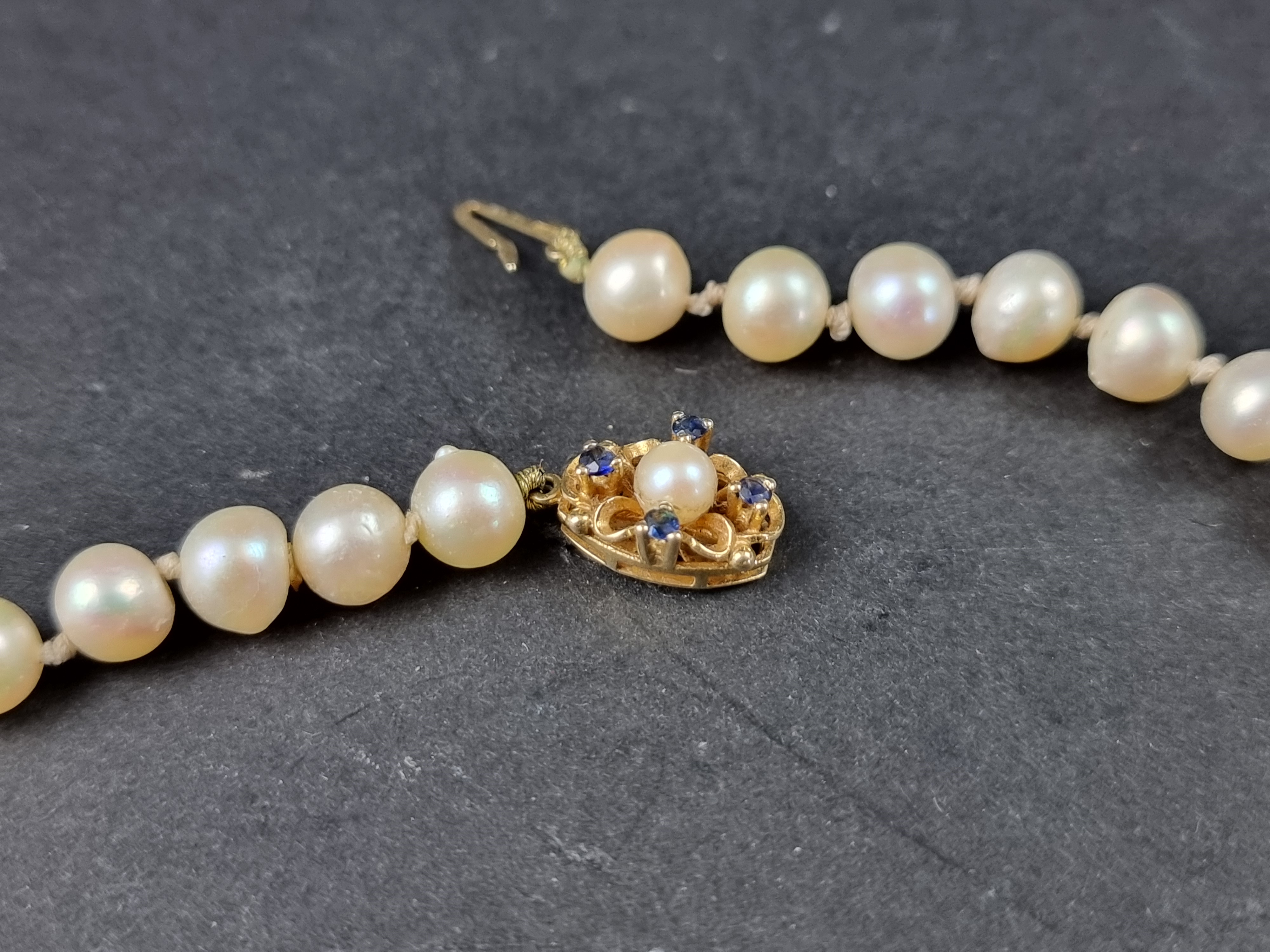 A cultured pearl necklace, having yellow metal clasp set pearl and four sapphires, stamped '9ct', - Image 2 of 3