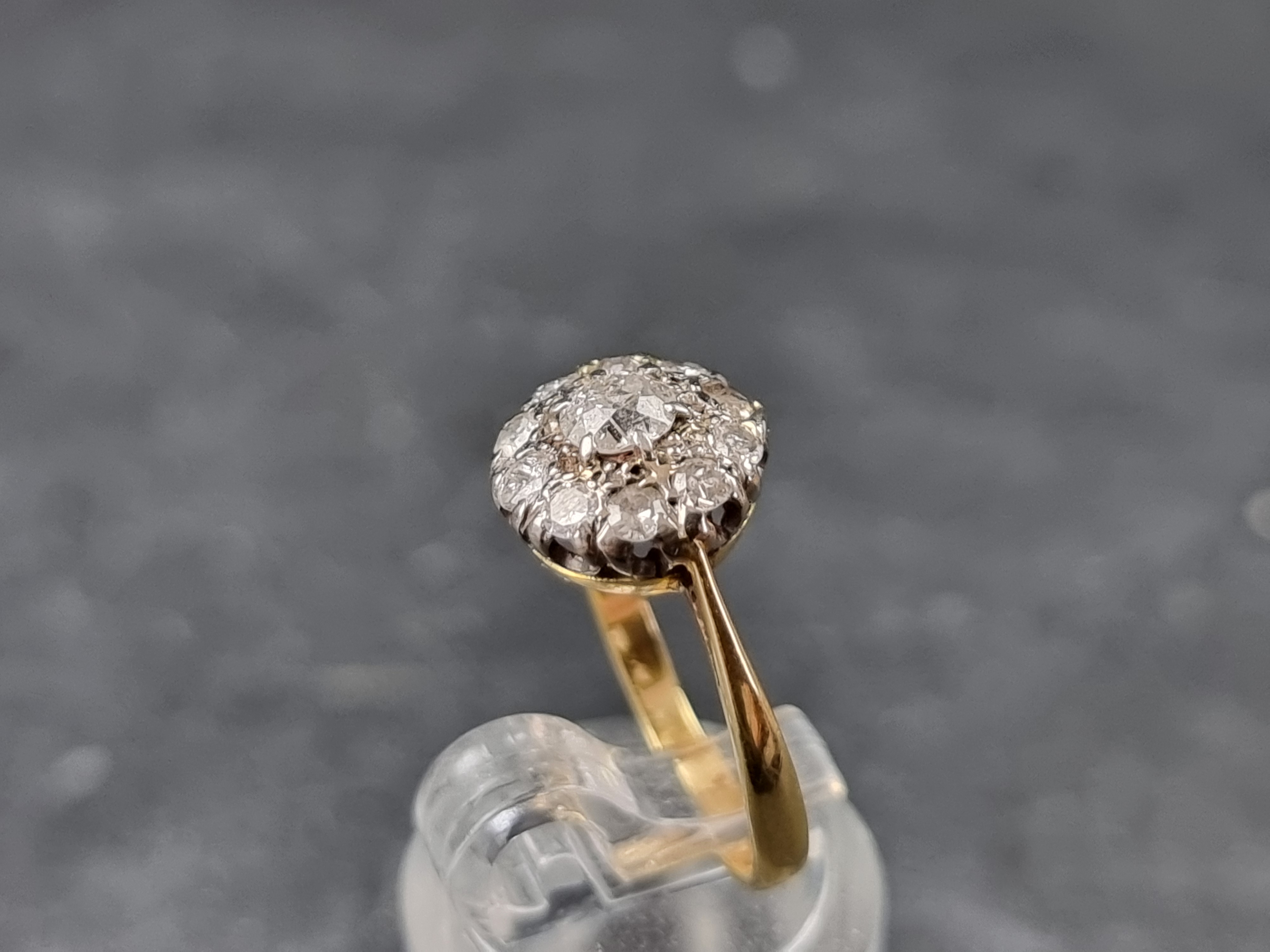 A diamond daisy cluster ring, stamped '18/Plat', size L 1/2. - Image 2 of 3