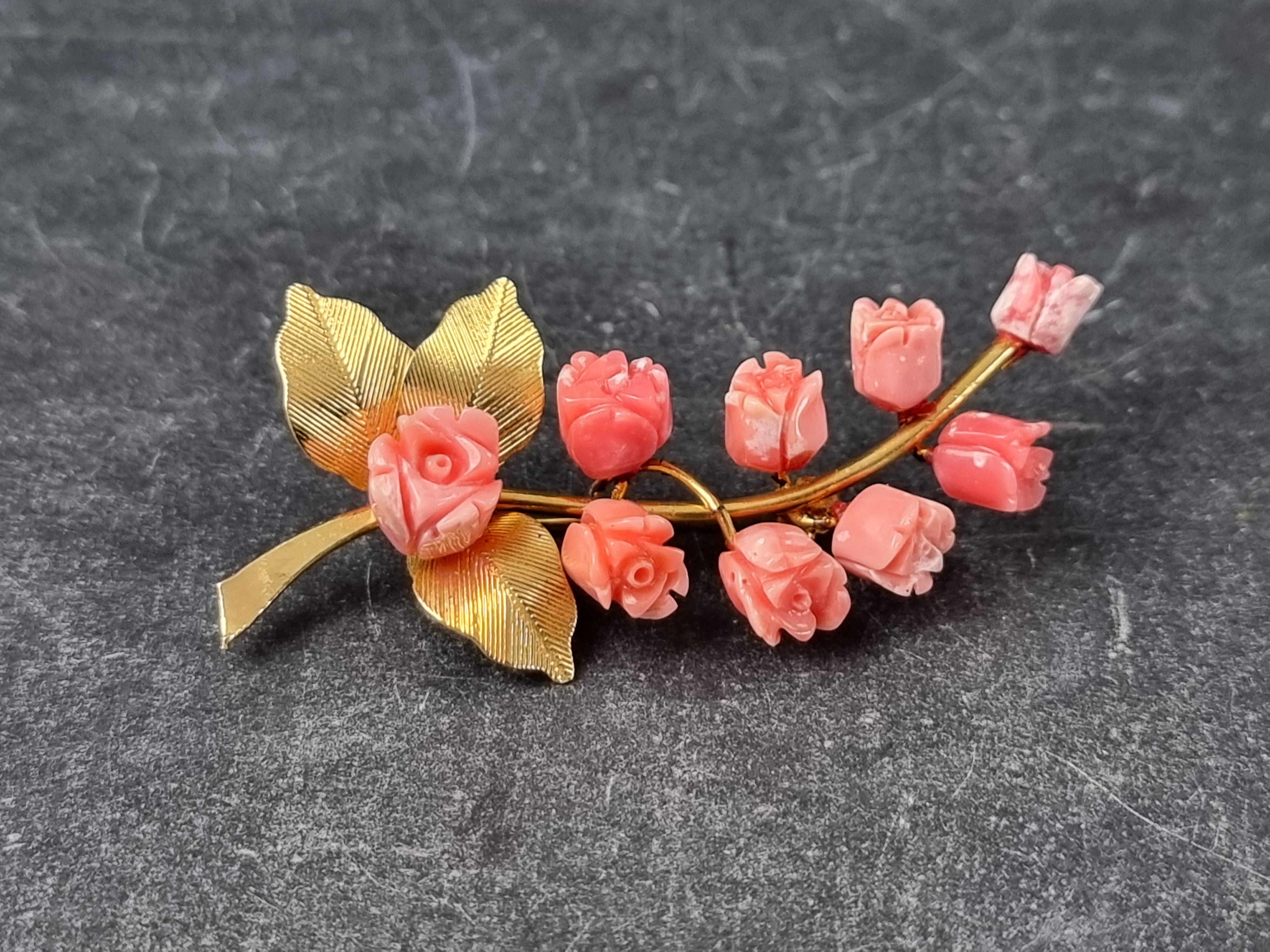 An Eastern gold plated and carved coral floral brooch, 64mm high.